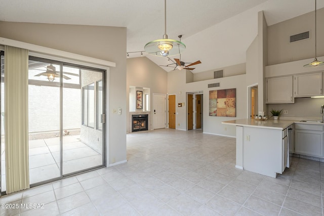 kitchen with pendant lighting, sink, kitchen peninsula, and ceiling fan