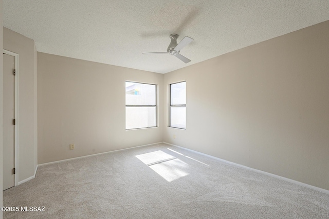 empty room featuring ceiling fan, light colored carpet, and a textured ceiling