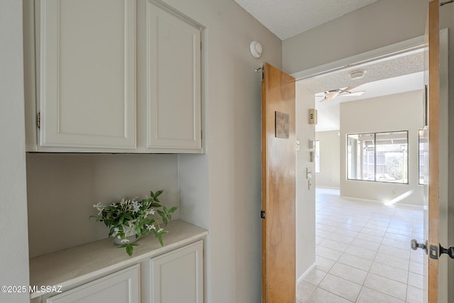 hallway with light tile patterned flooring and a textured ceiling