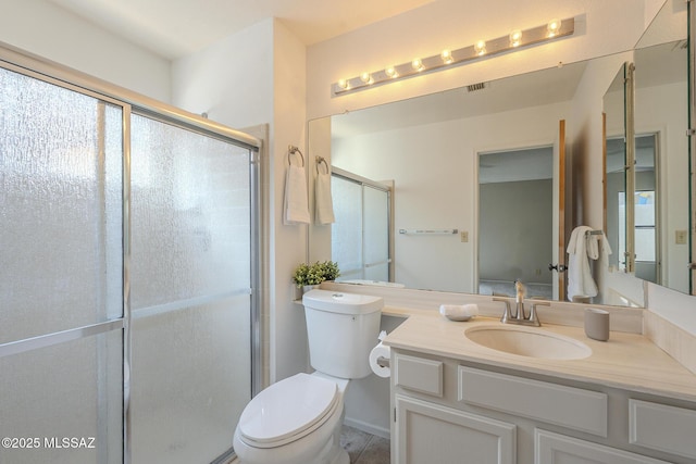 bathroom with vanity, toilet, and a shower with shower door