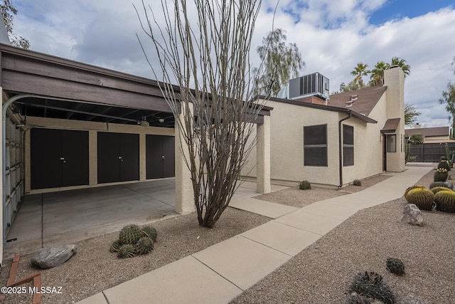 view of side of home featuring central AC and a carport