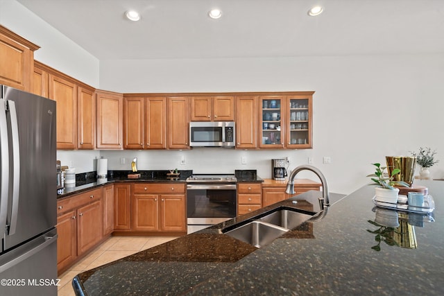 kitchen featuring sink, stainless steel appliances, and dark stone counters