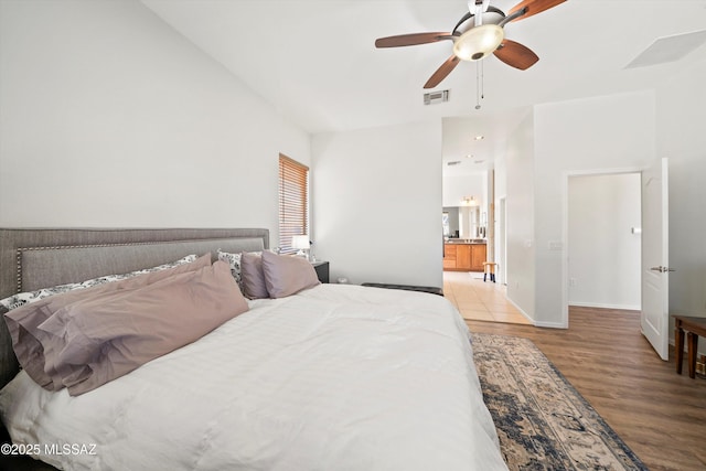 bedroom with ceiling fan, ensuite bathroom, and light hardwood / wood-style floors