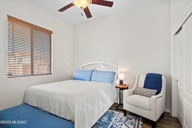 bedroom with dark hardwood / wood-style flooring, a closet, and ceiling fan