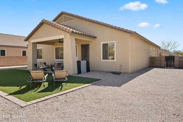 rear view of property with ceiling fan, a yard, and a patio area