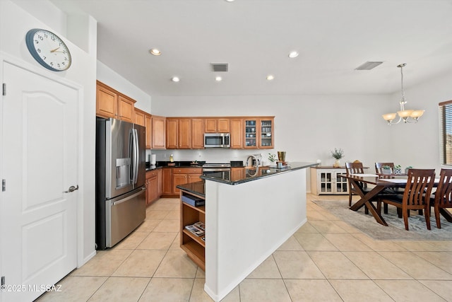 kitchen with light tile patterned flooring, appliances with stainless steel finishes, a chandelier, and hanging light fixtures