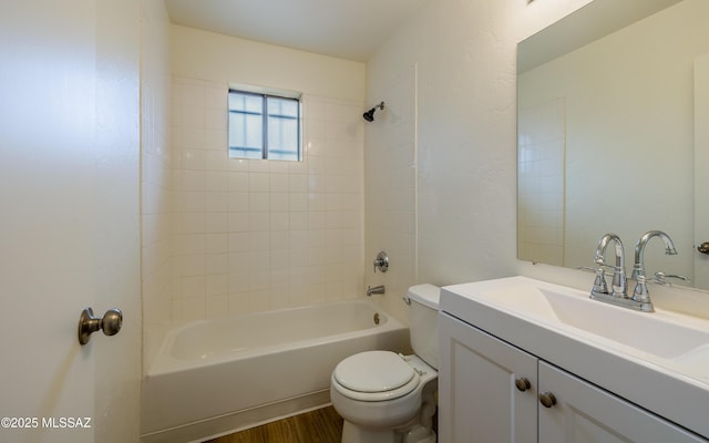 full bathroom with tiled shower / bath combo, vanity, hardwood / wood-style floors, and toilet