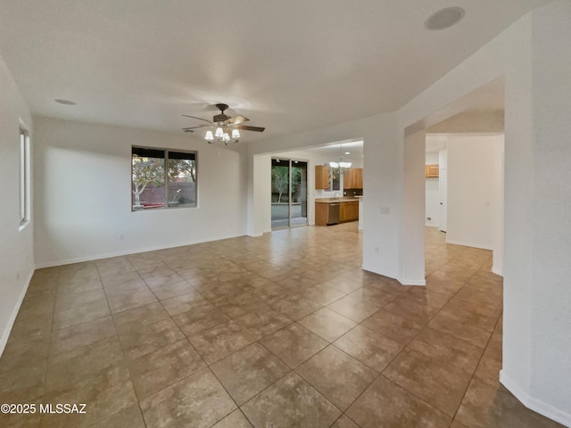 unfurnished living room with ceiling fan with notable chandelier