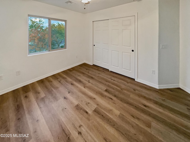 unfurnished bedroom featuring hardwood / wood-style floors and a closet