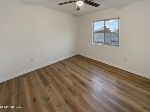 spare room with ceiling fan and dark hardwood / wood-style floors