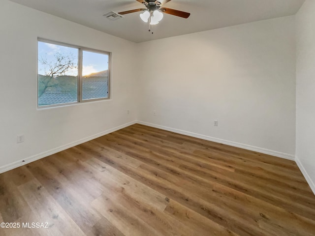 spare room with a water view, ceiling fan, and dark hardwood / wood-style flooring