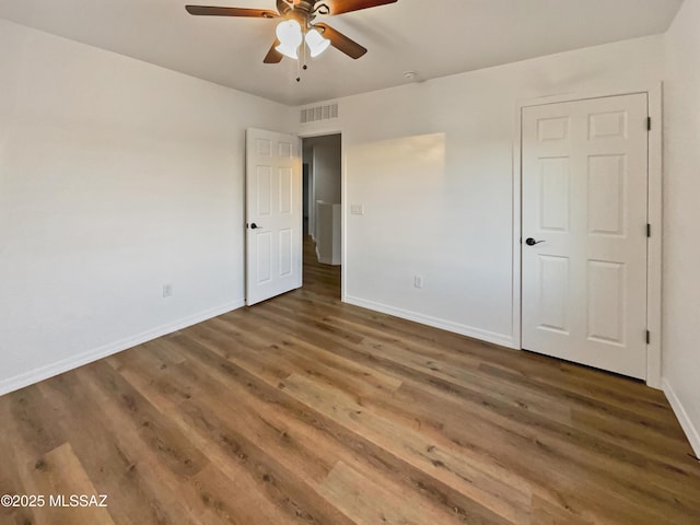 unfurnished bedroom featuring dark hardwood / wood-style floors and ceiling fan