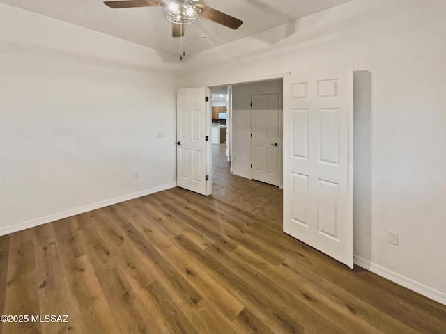 unfurnished bedroom with dark hardwood / wood-style flooring and ceiling fan