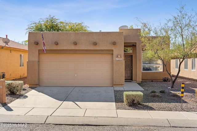 pueblo revival-style home with a garage