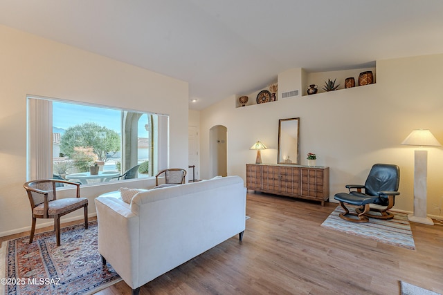 living room with high vaulted ceiling and light wood-type flooring