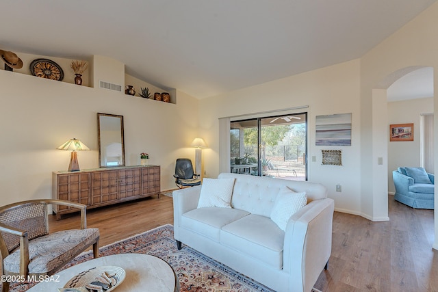 living room featuring vaulted ceiling and light wood-type flooring