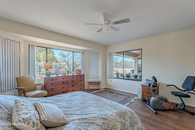 bedroom with multiple windows, ceiling fan, hardwood / wood-style flooring, and a textured ceiling