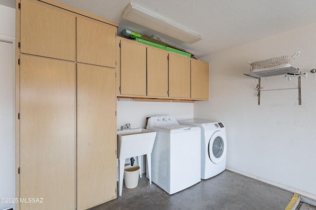 washroom featuring washer and clothes dryer, cabinets, and a textured ceiling