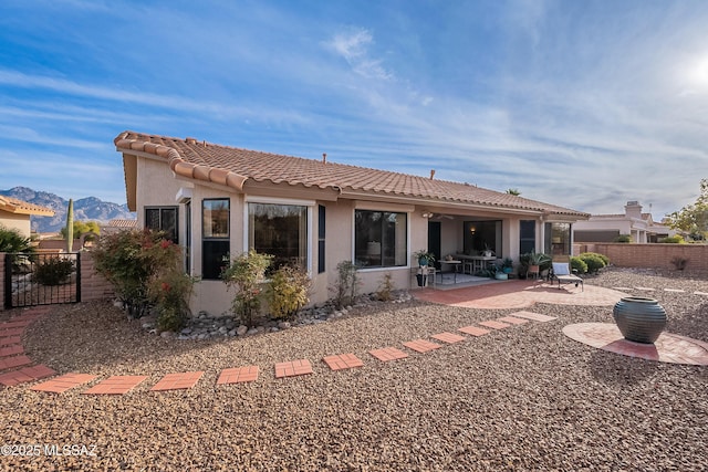 back of house with a mountain view and a patio