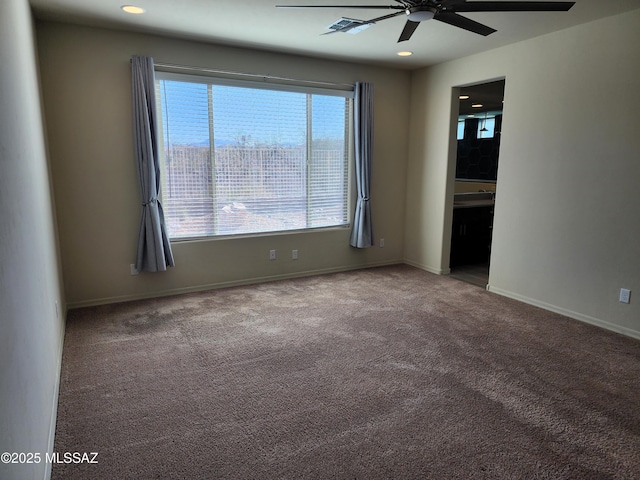 spare room featuring ceiling fan, carpet, and a wealth of natural light