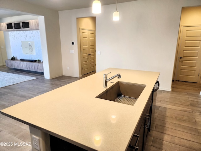 kitchen with hardwood / wood-style flooring, dishwasher, sink, and decorative light fixtures