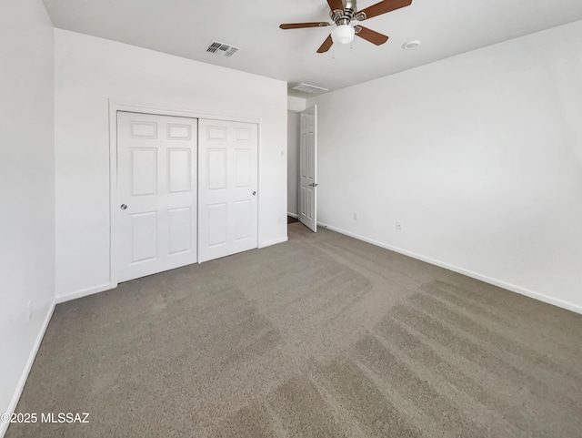 unfurnished bedroom featuring dark carpet, ceiling fan, and a closet