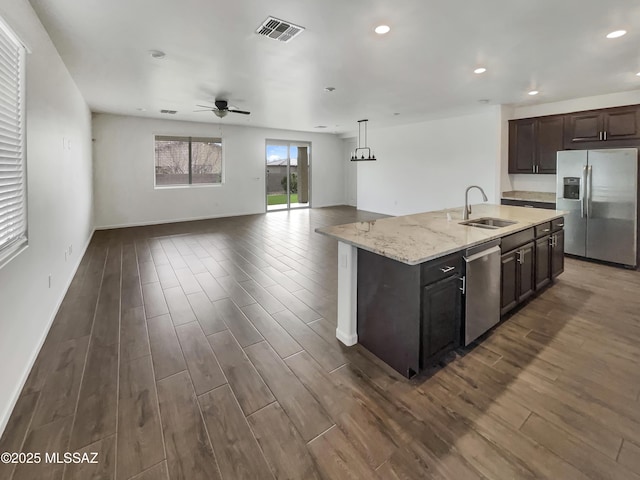 kitchen with sink, a center island with sink, pendant lighting, ceiling fan, and stainless steel appliances