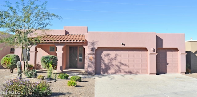 pueblo-style house featuring a garage