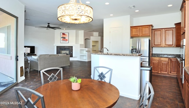 dining room with sink, a fireplace, and ceiling fan