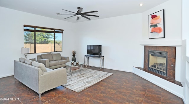 living room with a tiled fireplace and ceiling fan