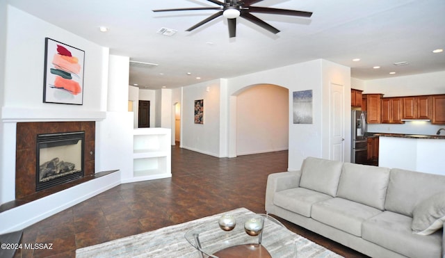 living room with a tiled fireplace and built in features