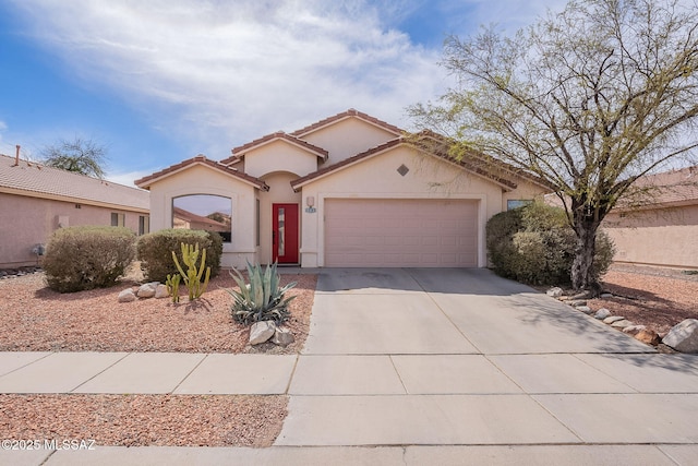 mediterranean / spanish-style home with concrete driveway, a tile roof, an attached garage, and stucco siding