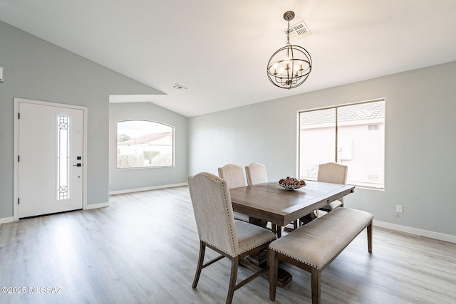 dining space with lofted ceiling, light wood finished floors, visible vents, and a chandelier