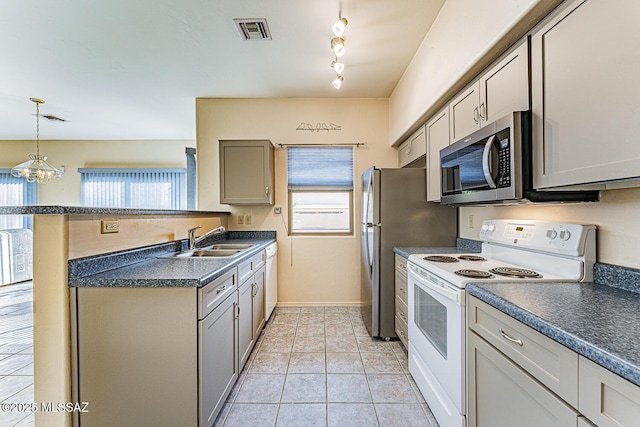 kitchen featuring sink, white appliances, gray cabinets, light tile patterned floors, and hanging light fixtures