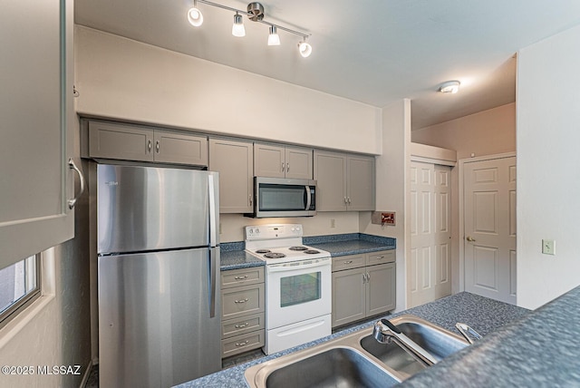 kitchen with appliances with stainless steel finishes, gray cabinets, and sink