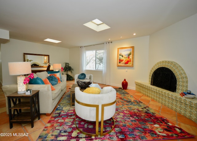 tiled living room featuring a brick fireplace and a skylight