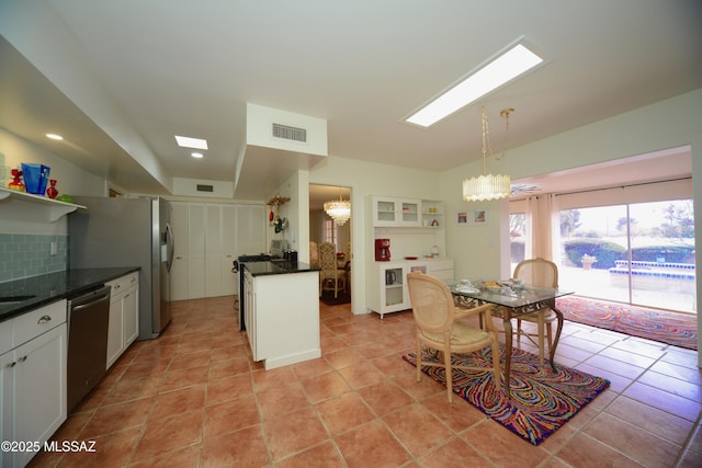 kitchen featuring dishwasher, hanging light fixtures, a notable chandelier, white cabinets, and decorative backsplash