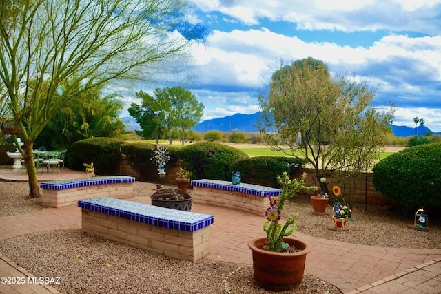 view of patio / terrace with a mountain view and an outdoor fire pit