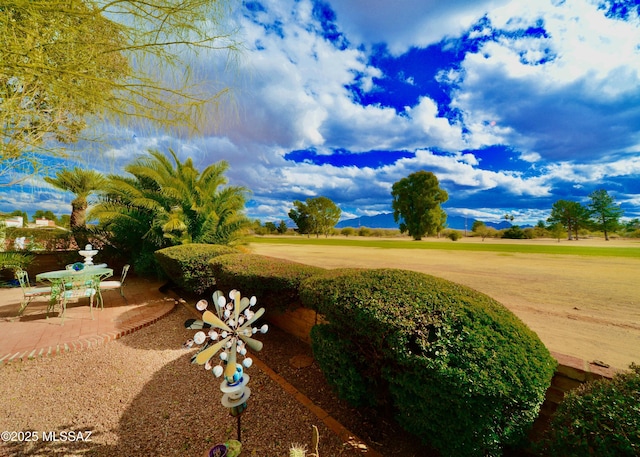 view of community featuring a mountain view and a patio area