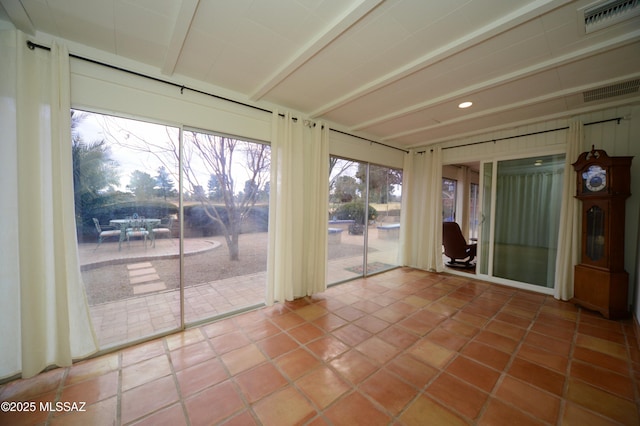 unfurnished sunroom featuring beamed ceiling