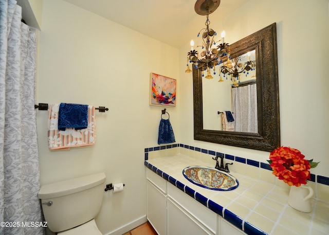 bathroom with vanity, a chandelier, and toilet