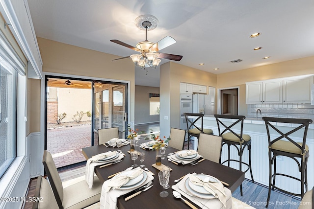 dining area featuring hardwood / wood-style floors, sink, and ceiling fan