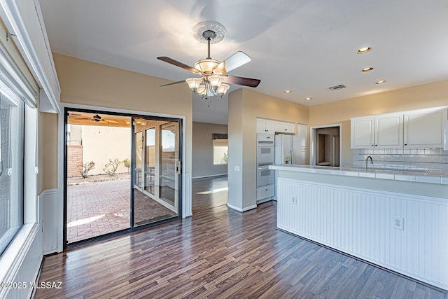 kitchen with white appliances, white cabinetry, tile counters, dark hardwood / wood-style flooring, and decorative backsplash