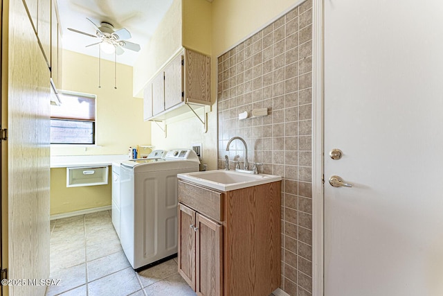 laundry room featuring sink, light tile patterned floors, ceiling fan, cabinets, and independent washer and dryer