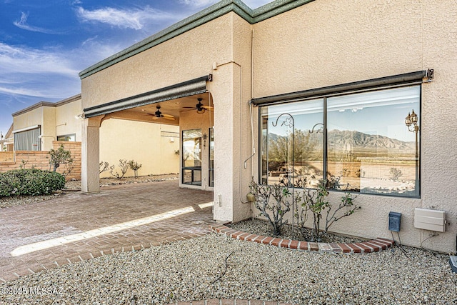 view of side of property featuring ceiling fan and a patio