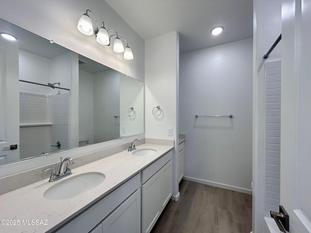bathroom with toilet, a sink, walk in shower, and wood finished floors