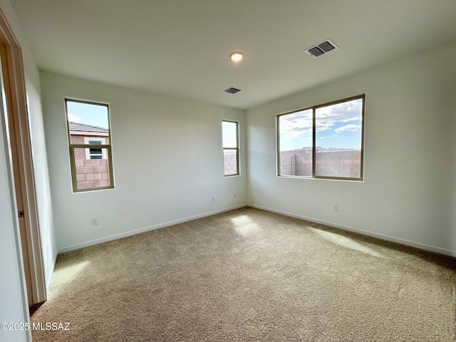 empty room with baseboards, carpet floors, and visible vents