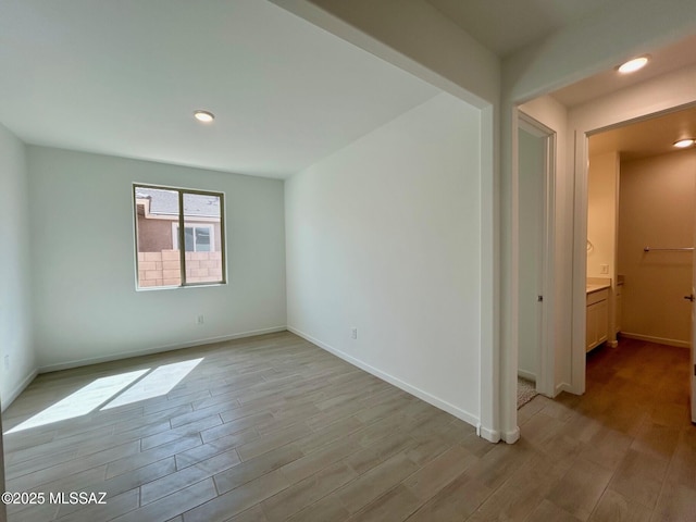 unfurnished room featuring baseboards, light wood finished floors, and recessed lighting