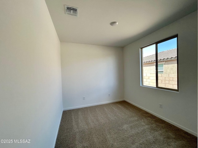 empty room featuring baseboards, visible vents, and carpet