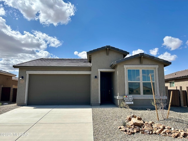 single story home with a tile roof, stucco siding, driveway, and a garage